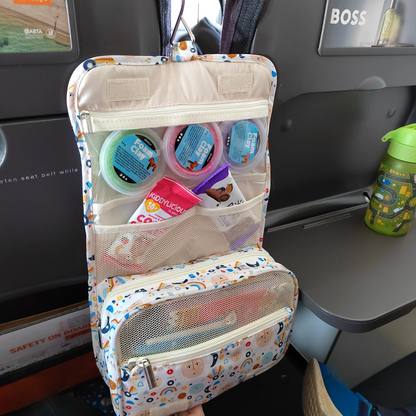 Children's toiletry bag with various items and toys on a car seat